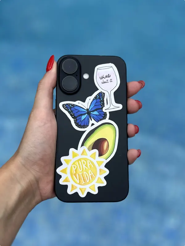Celular negro con stickers de mariposa, palta y sol